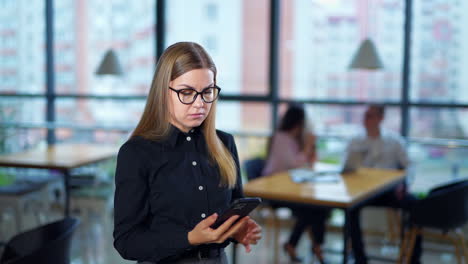 unpleasant phone call on job matters. angry lady dissatisfied with her phone conversation and ends the call. colleagues at the table in blur on backdrop.