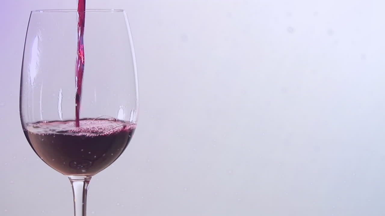 Animazione di neve che cade su bicchiere di vino su sfondo bianco