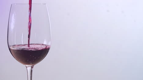 animation of snow falling over glass of wine on white background