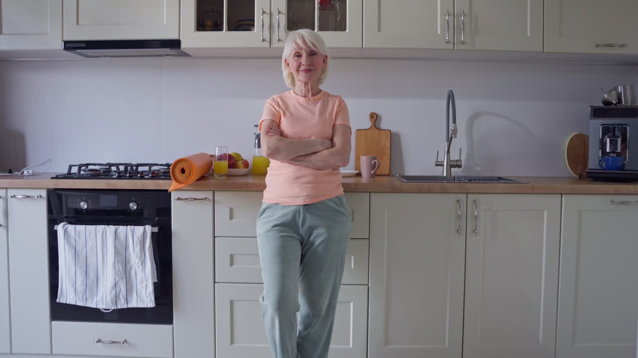 Donna anziana in cucina con il tappetino da yoga