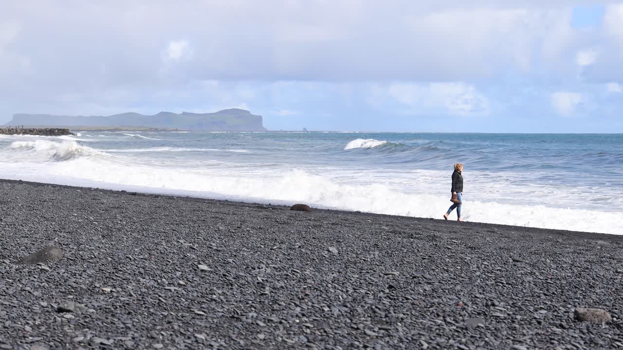 걷는 파도에 의해 해변에 여자