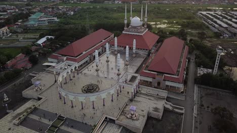 aerial view of the great mosque of central java (majt) in suset time. th sun is orange and the weather is cloudy. cyrcle drone shot