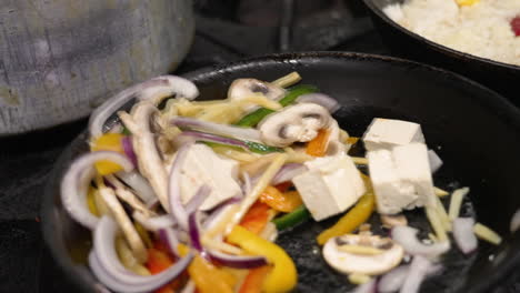 stirfrying vegetables and tofu over high heat in commercial kitchen, tossing cooking vegetable, slow motion close up 4k