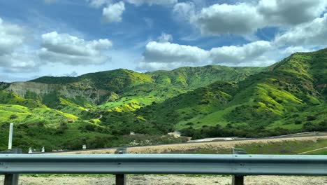 green mountains viewed from a moving car on the freeway