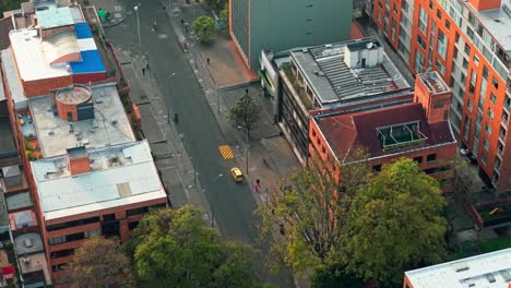 an aerial view taken by a drone of the city of bogotá with orange buildings and streets with cars.