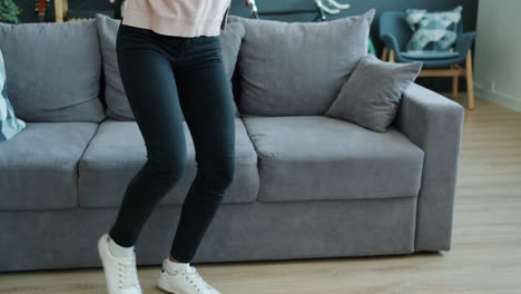 young woman dancing to music at home