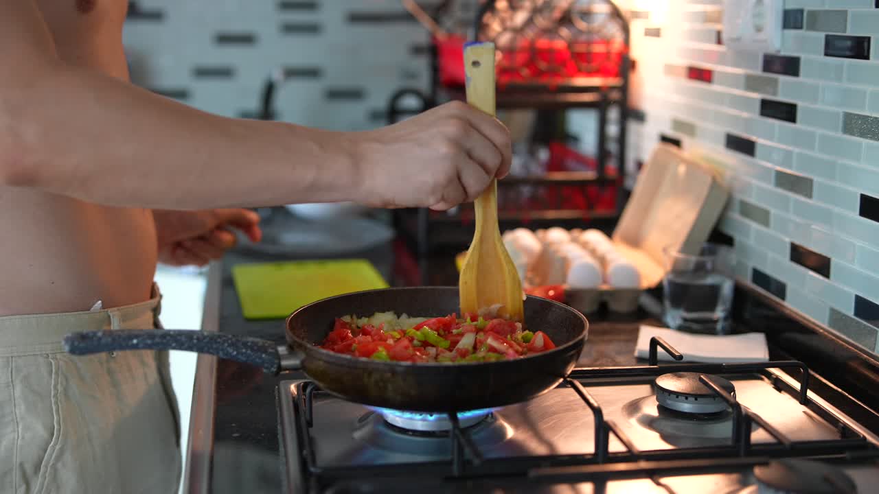 persona cocinando verduras y huevos en una cocina