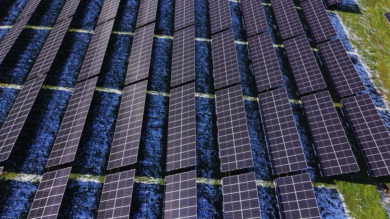 I pannelli solari coprono il terreno in un sito di energia rinnovabile vicino a un campo.