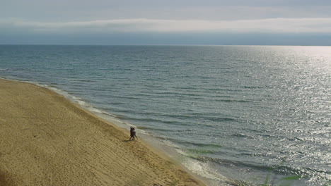 las olas tranquilas del océano se estrellan en el paisaje natural. pareja corriendo playa de fondo.