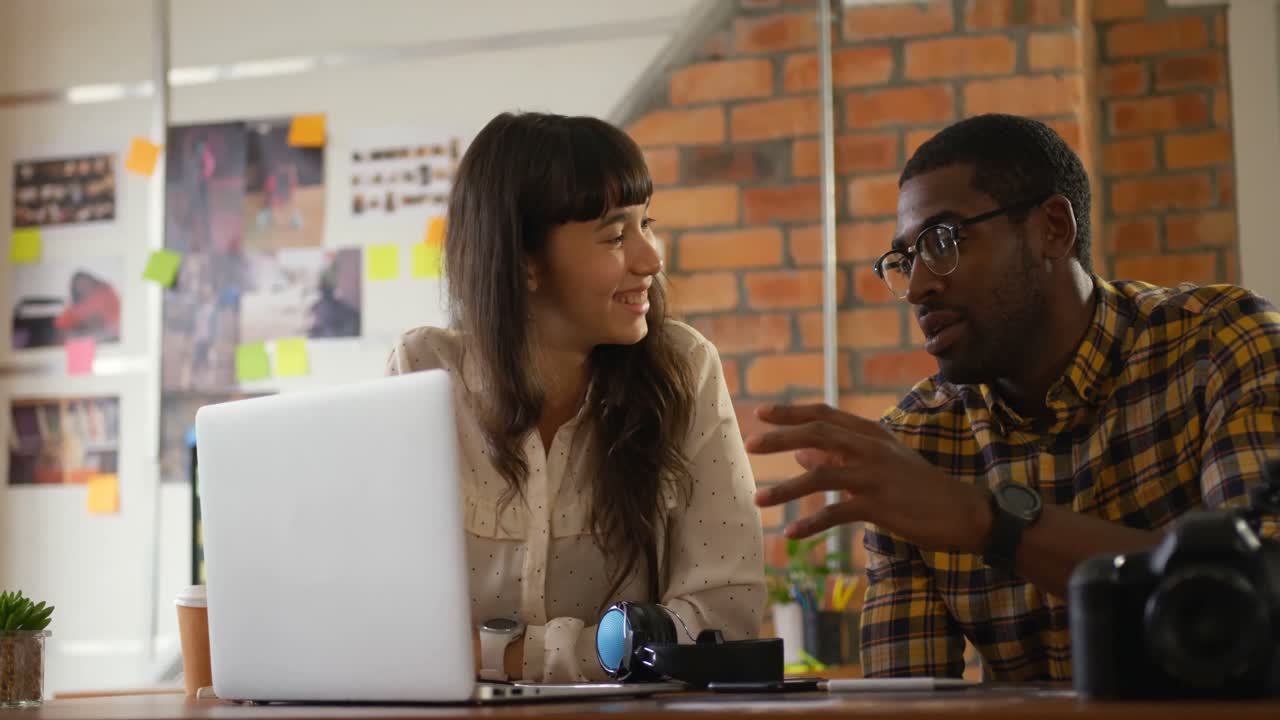 Graphic designers working together at desk in a modern office 4k