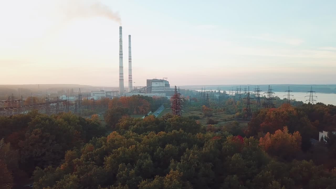 view of the territory of the power plant with power lines on the background of the river and trees. Aerial view