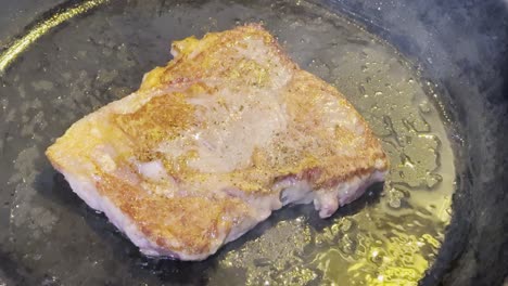 highly marbled steak sizzling in hot oil