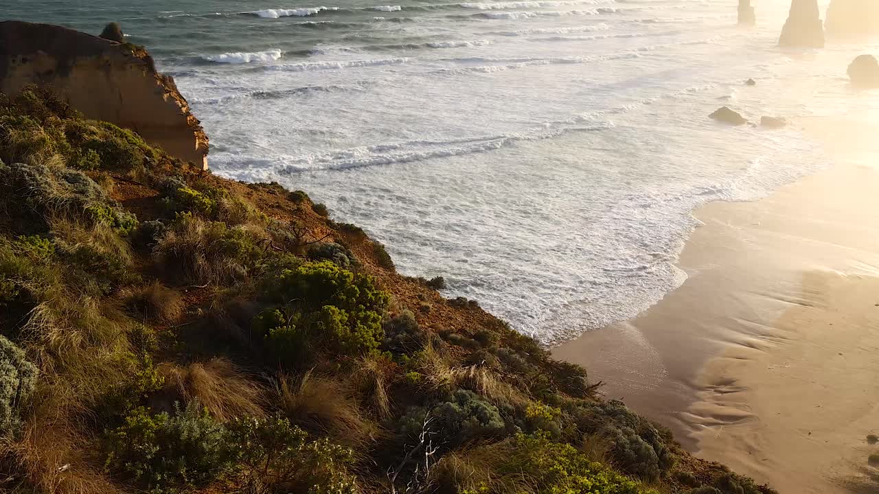 Waves crashing on the shore at sunset