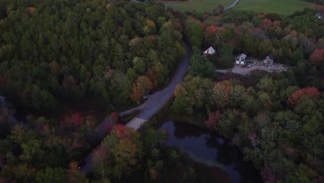 A-long-crane-shot-capturing-forest,-homes,-road,-and-the-skyline-in-Maine