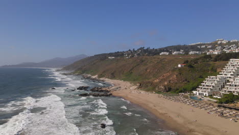 AERIAL---Sunny-day-at-the-beach,-Zapallar,-Valparaiso,-Chile,-wide-forward-shot