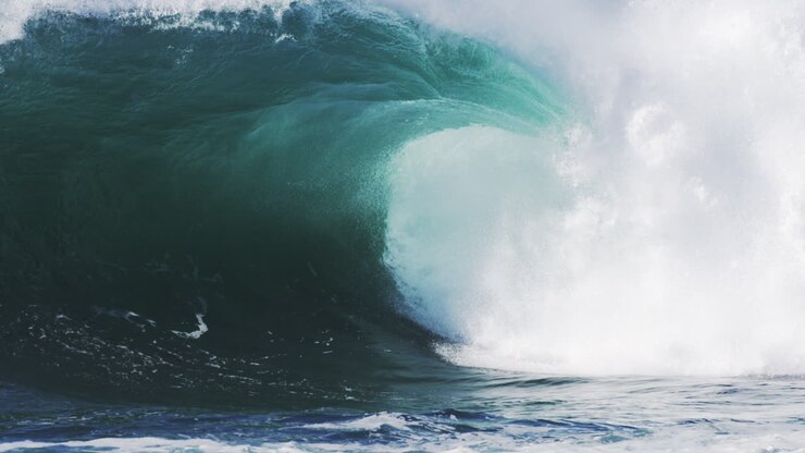 Crashing wave throws spray into the air, light piercing through the thick mist