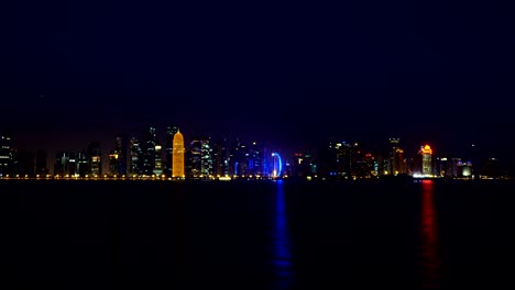 doha night city video landscape, qatar, middle east. illuminated skyscrapers on a west bay reflected in a water of gulf. view from mia park