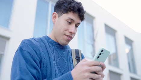 Young student browsing on smartphone in urban setting