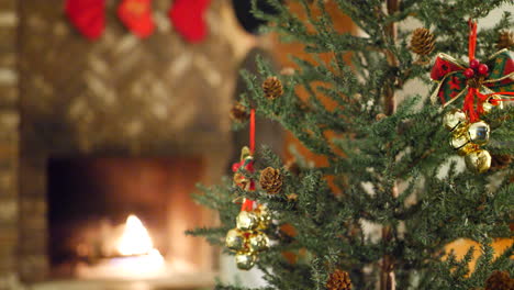 a young man placing stockings over the fireplace in front of the christmas tree for the holidays and enjoying the warmth of the fire