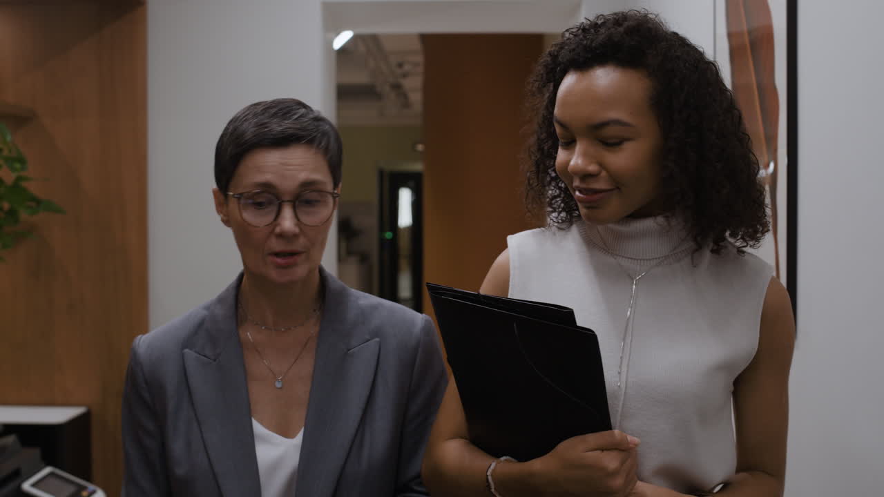 Businesswomen Talking in Office Hallway