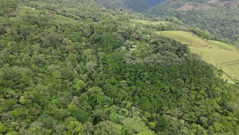 aerial view moving forward shot, scenic view of trees and hills of la tigra rainforest in costa rica, on a bright sunny day