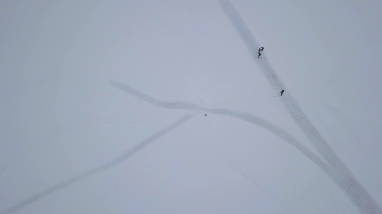 얼어붙은 호수에서 야외 겨울 활동에 참여하면서 즐거운 시간을 보내는 가족의 머리 위 영상 확대