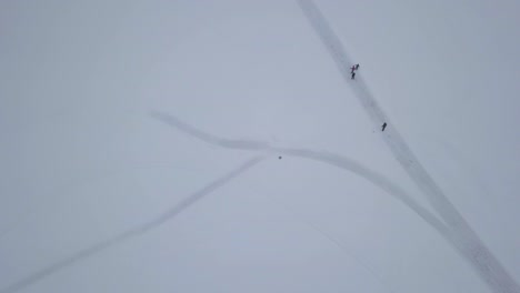zoom in over head footage of family having fun while participating in outdoor winter activities on frozen lake