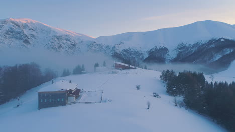 Aerial,-drone-shot-of-Sunset-over-Botev-Peak-and-Pleven-Hut-in-the-Balkan-mountains,-on-a-sunny,-winter,-dawn,-in-Central-Balkan-National-Park,-Bulgaria