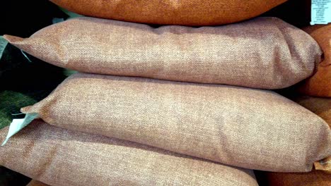 stacked brown and beige pillows on a store shelf, soft textile close up