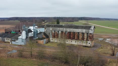 aerial pan of soviet union rusty granary shed tank and grain farm barn