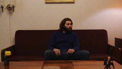 hombre sentado en un sofá en una sala de estar vintage