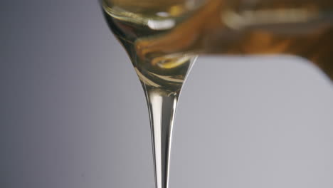 drops of honey dripping out of a honey jar