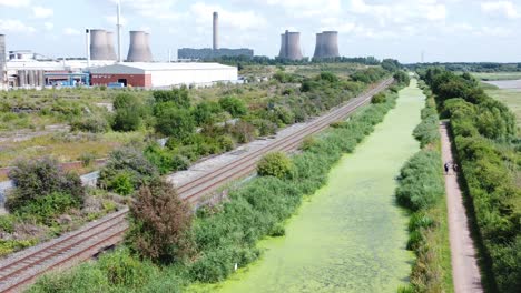 canal cubierto de algas verdes que conduce a la industria de la central eléctrica vista aérea de drones tiro ascendente