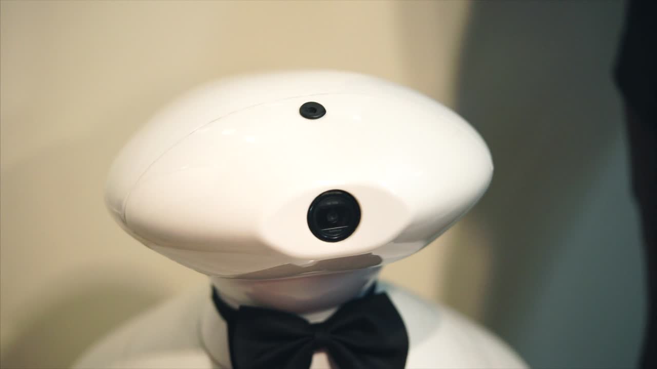 White robot head with camera and bow tie