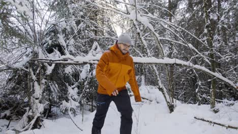 Hombre-En-Equipo-Cálido-Explorando-Un-Bosque-Cubierto-De-Nieve-Espesa