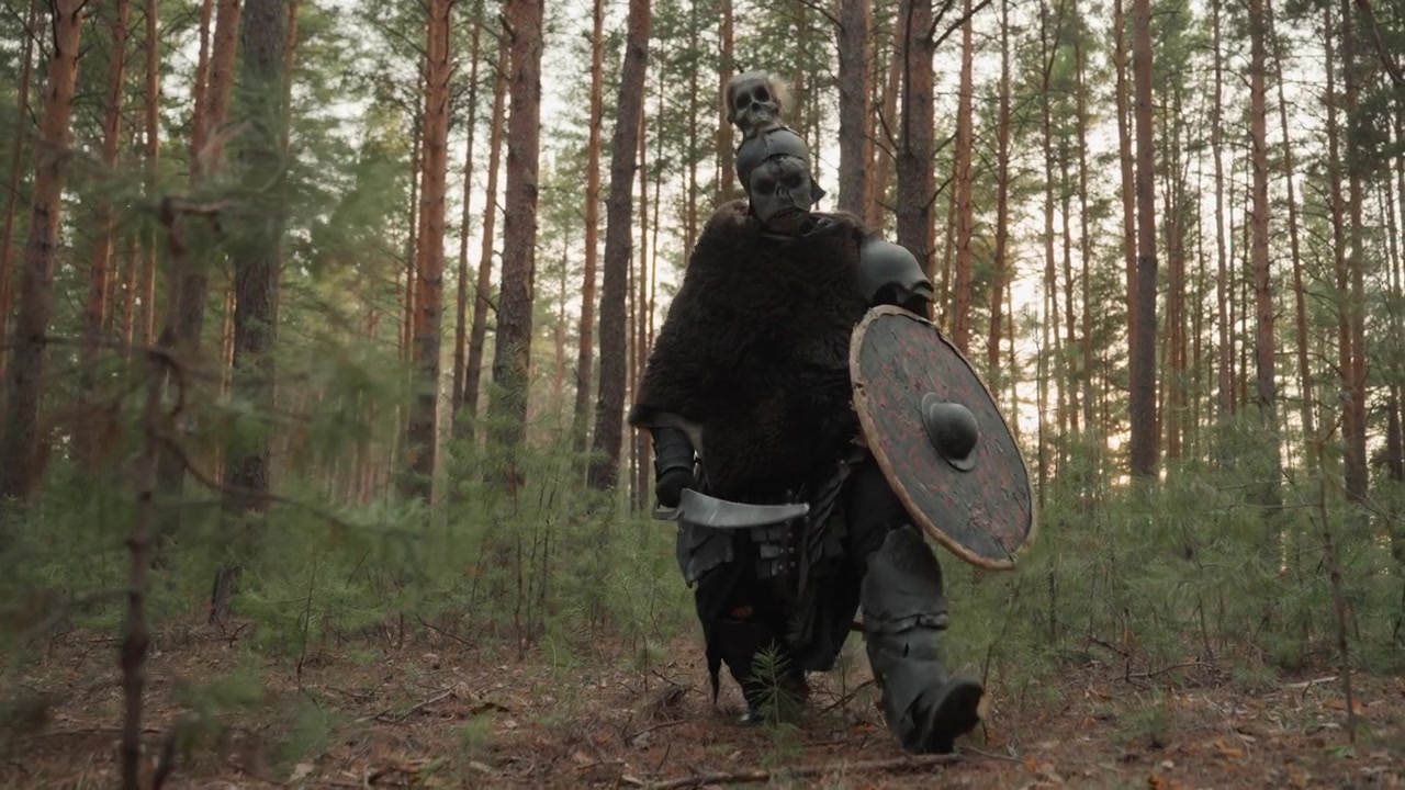 Un guerriero corazzato carica attraverso una fitta pineta, avanzando con scudo rotondo e lancia mentre il mantello di pelliccia gli sventola dietro, creando un teso inseguimento nel bosco, forte movimento e luce solare drammatica.