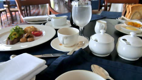 elegant breakfast setting with coffee, vegetables, potatoes, and mushrooms on white china