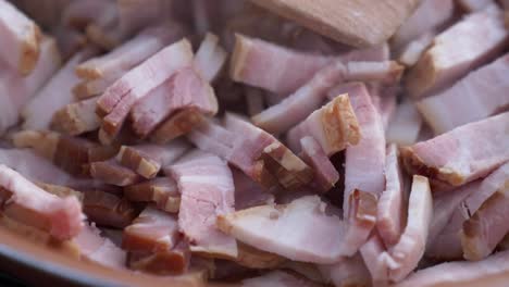 extreme close up of fresh pork meat cooking in a skillet with steam