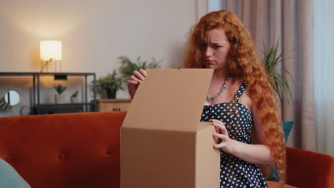 angry dissatisfied shopper redhead woman unpacking parcel feeling upset, confused, wrong delivery