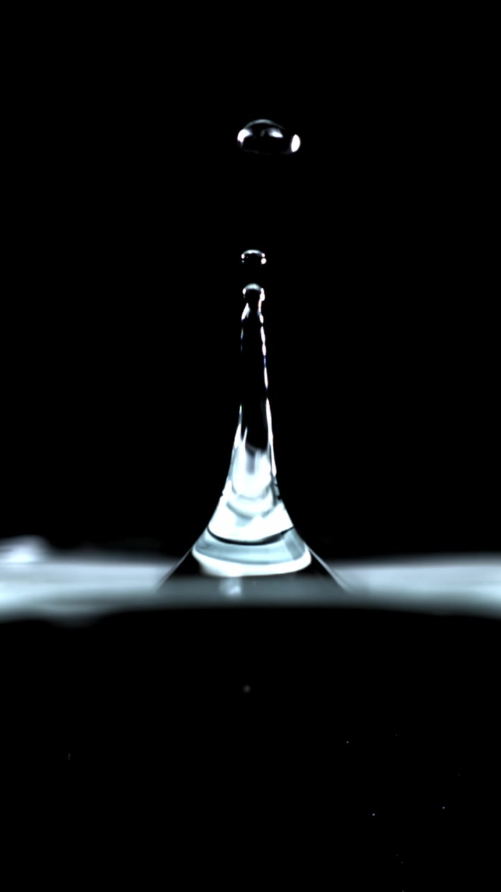 Slow Motion Water Drop Falling and Splashing on a Black Background