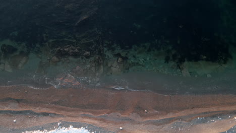 Drohnenaufnahme-Mit-Direktem-Blick-Auf-Einen-Strand-Im-Frühling,-Wenn-Noch-Etwas-Schnee-Auf-Dem-Boden-Liegt