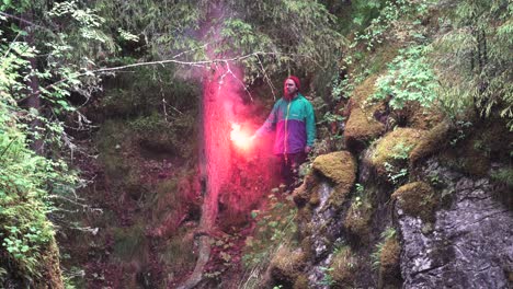 man with red flare in forest