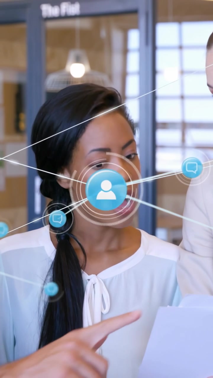 Vertical video: Team lead reading docs guiding biz team after peer taps tablet with network overlay