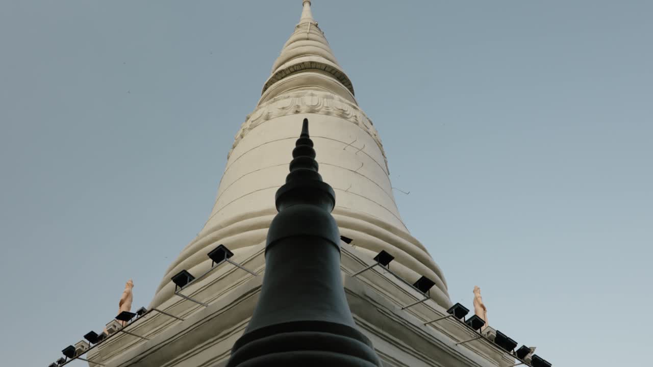 Veduta dal basso di uno stupa bianco e un pinnacolo scuro a Phnom Penh, Cambogia