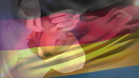 animation of waving germany flag against doctor placing oxygen mask on a female patient at hospital