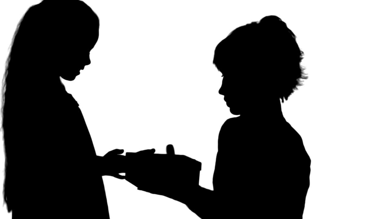 Silhouette Pretty caucasian woman getting chrismas gift from her daughter track matte