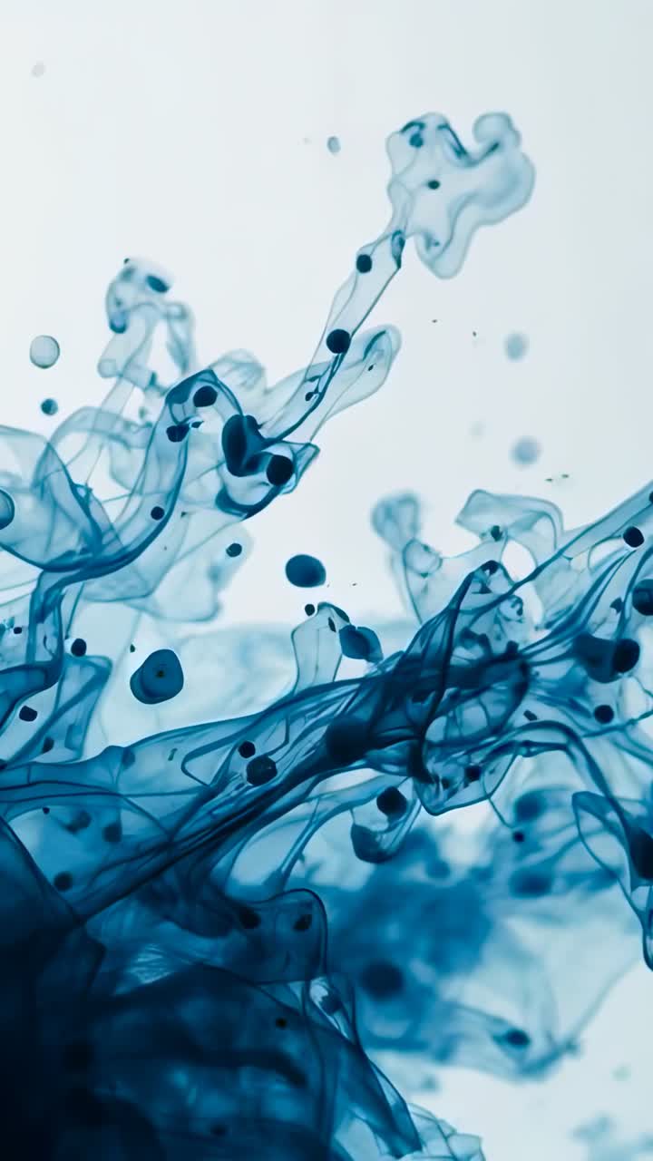 Video verticale: pigmento blu che cade in un serbatoio d'acqua, pennacchi e gocce che si diffondono su sfondo bianco