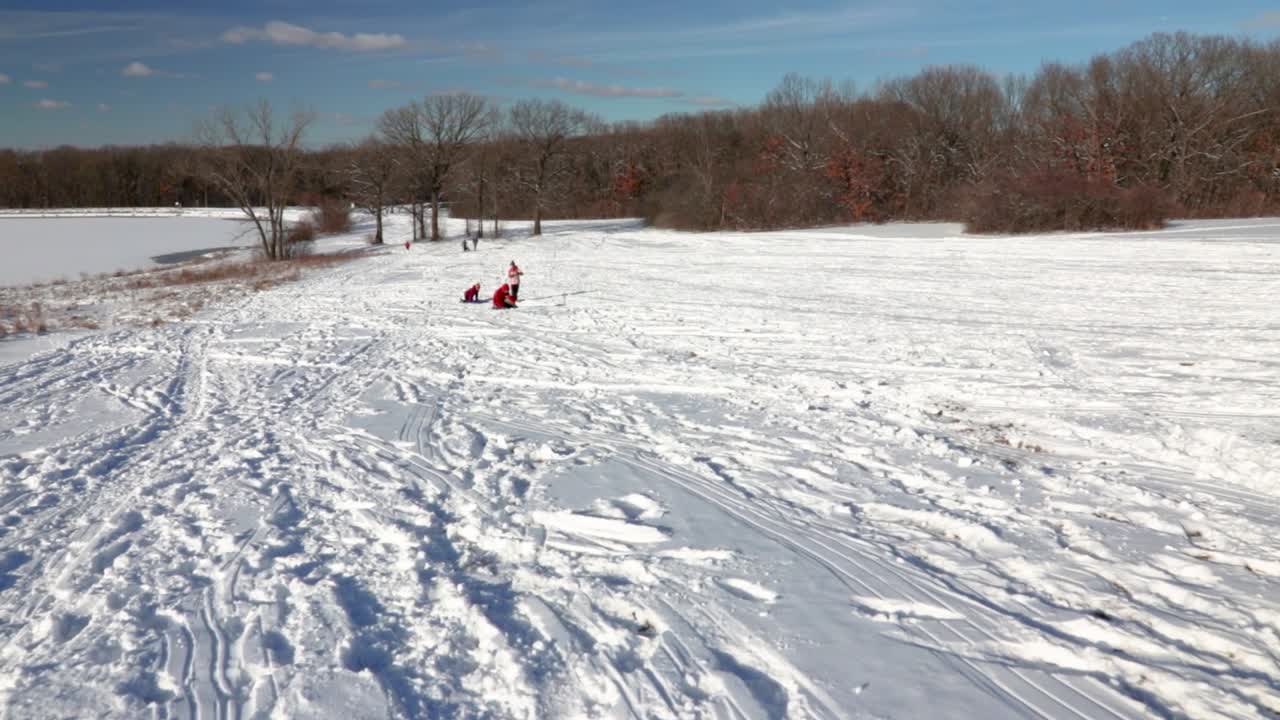 una toma amplia de zoom en cámara lenta de tres niños participando en un cantor juguetón en la nieve