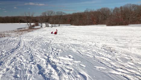 A-slow-motion-zooming-wide-shot-of-three-children-engaged-in-playful-chanter-in-the-snow