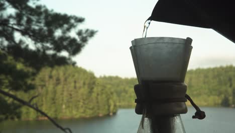 Filling-Chemex-and-paper-coffee-filter-with-water-for-coffee-extraction-in-canadian-northern-forest-while-hiking